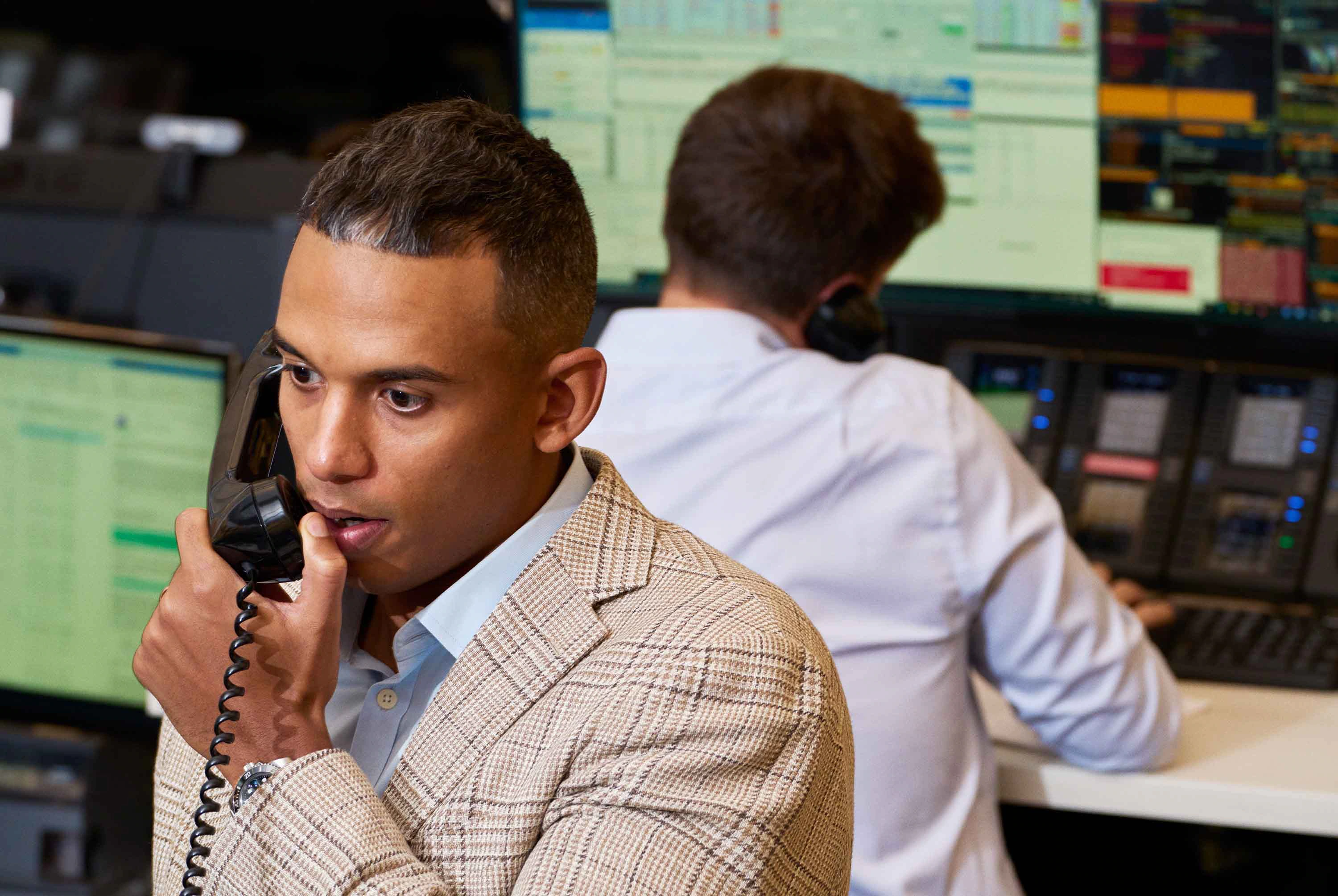 A person managing their finances on a laptop and phone, with a  Luma Haven Mark card nearby
